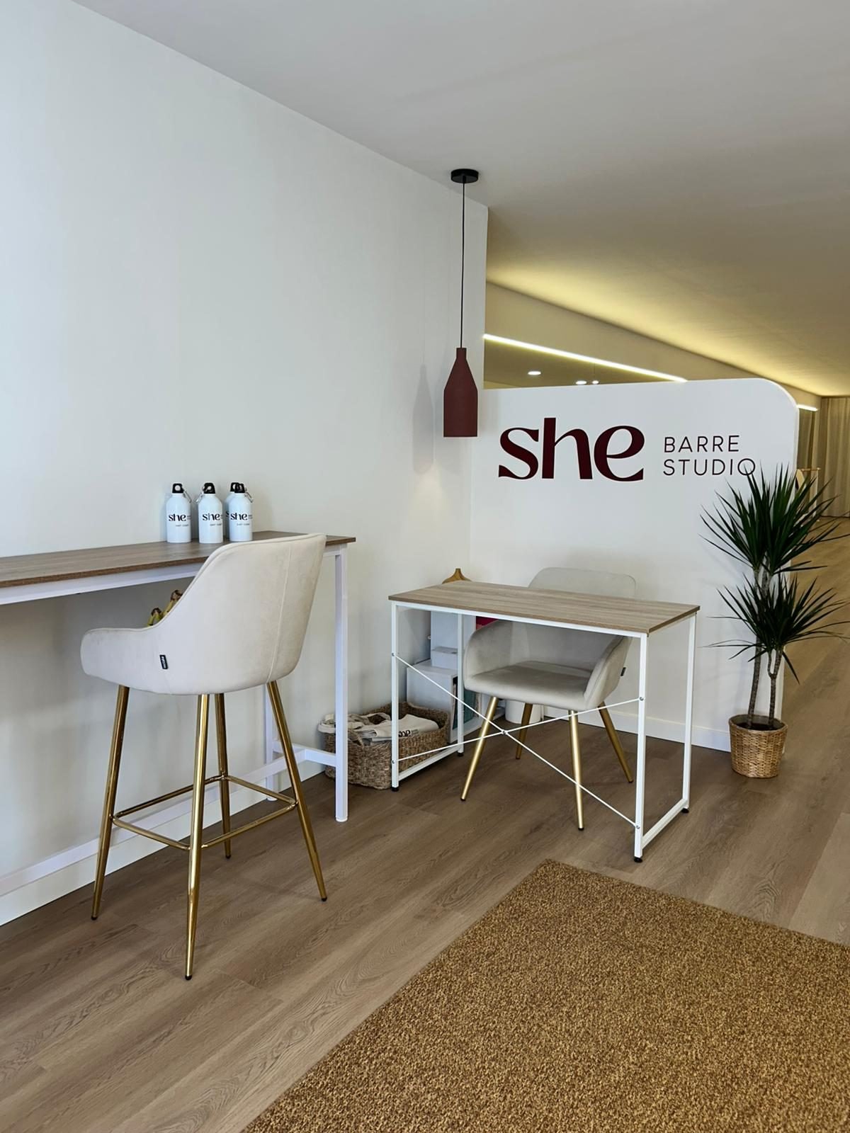 Recepción del estudio SHE Barre con mesa y botellas de agua