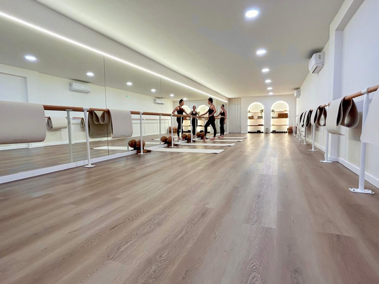 Sala de SHE Barre Sant Cugat con barras, espejos y suelo de madera durante una clase