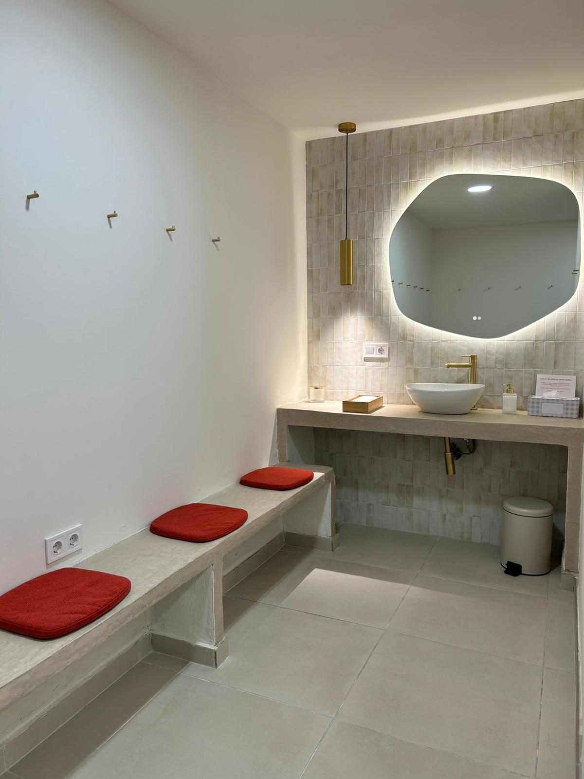 Vestuario con bancos, perchas y lavabo